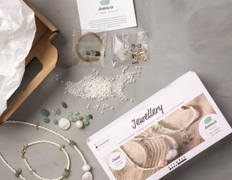 Kits de bricolage de bijoux ouverts et contenu affich&eacute; sur une table