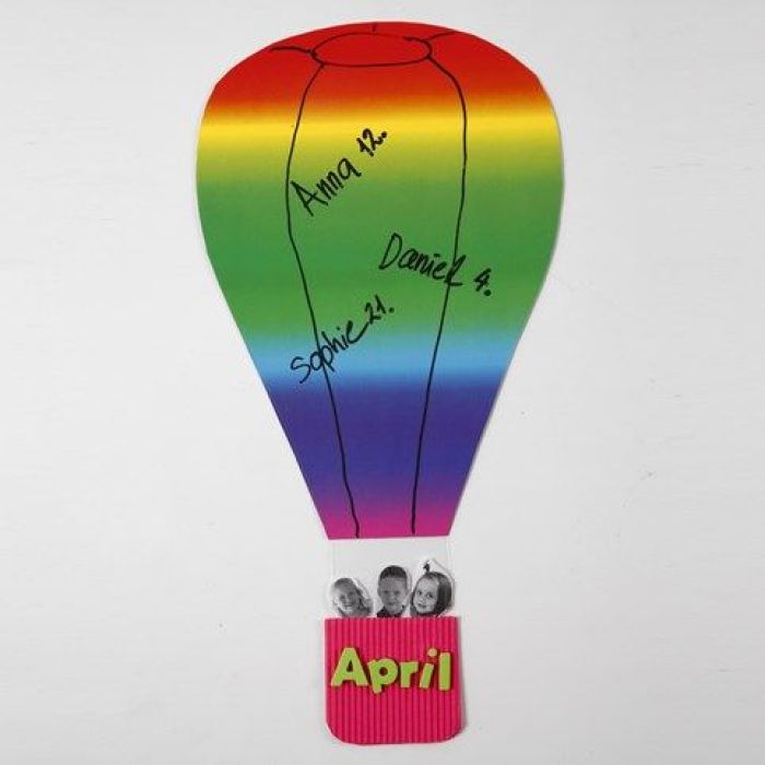 Une montgolfière faite de papier cartonné arc-en-ciel et d'un panier en carton ondulé
