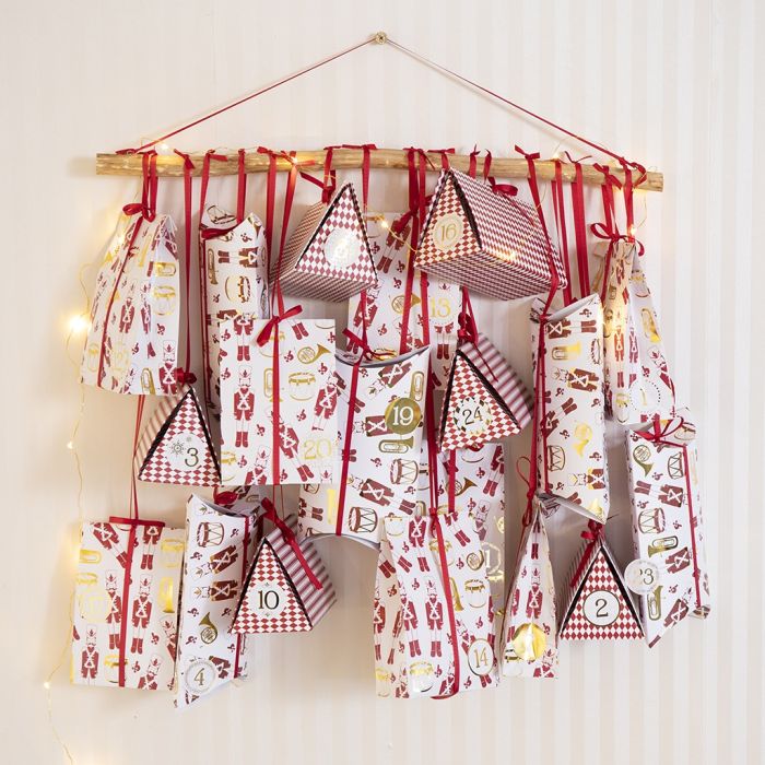 Un calendrier de l’Avent avec un mélange de boîtes cadeaux pliantes et de sacs en papier