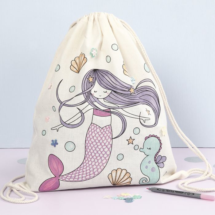 Un sac à cordon avec un motif de sirène préimprimé décoré avec des marqueurs textiles et des sequins.