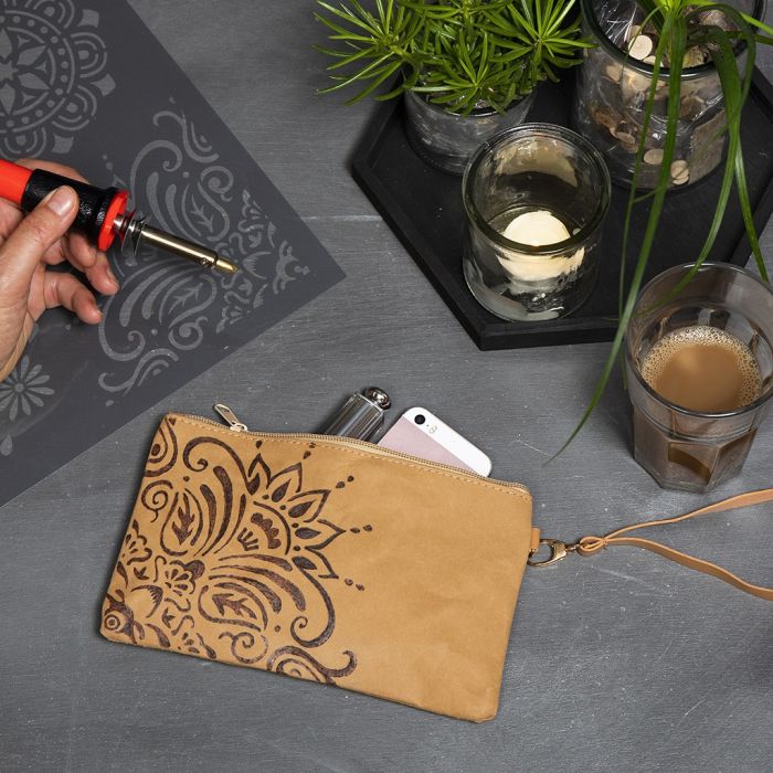 Une pochette en papier simili cuir décorée d’un motif ethnique à l’aide d’un pyrograveur