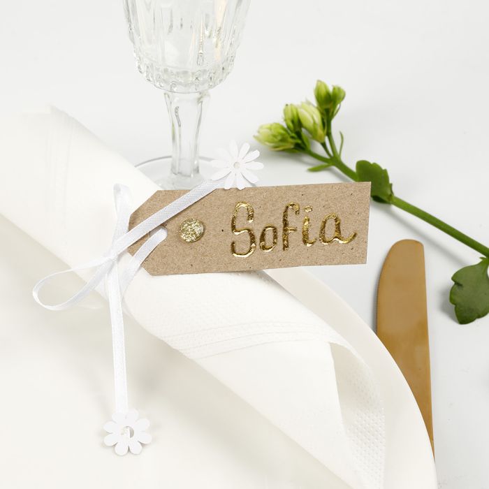 Une carte de place réalisée à partir d’une étiquette manille décorée avec du Deco Foil, des strass et un ruban en satin