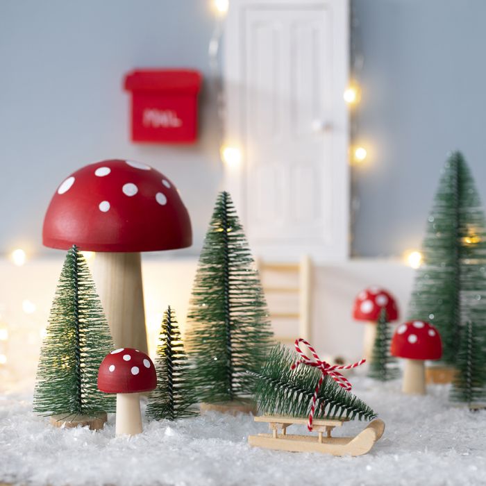 Le lutin place un sapin de Noël devant la porte de son lutin.