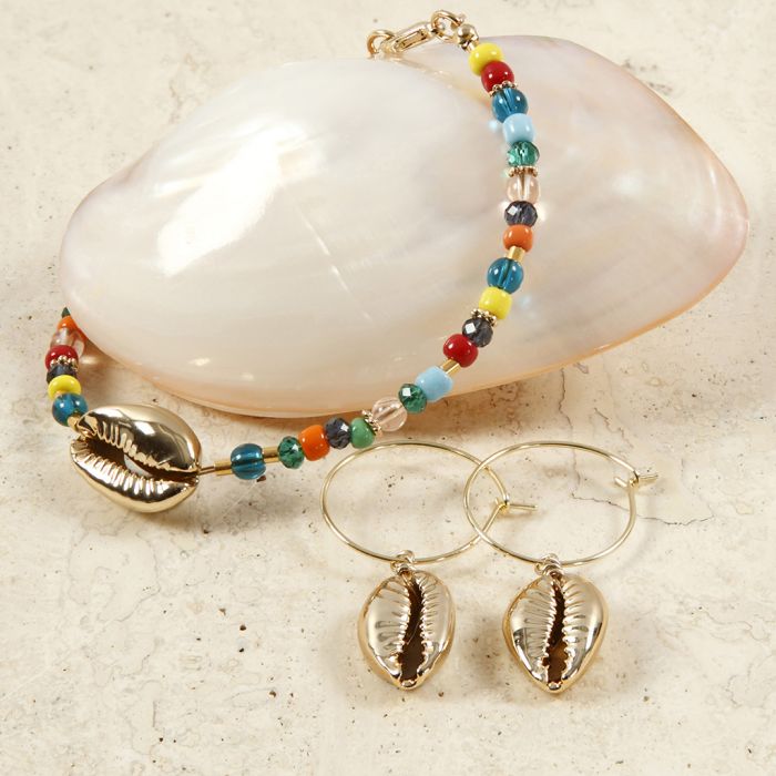 Un bracelet de perles et des boucles d’oreilles avec des coquillages dorés.
