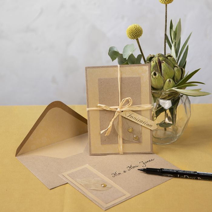 Une invitation en carton recyclé décorée d’une feuille squelette.