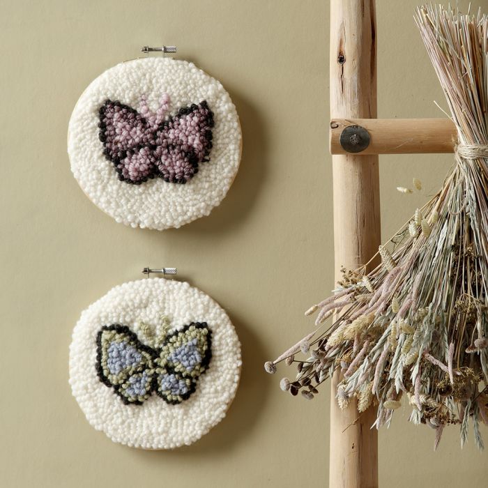 Papillons brodés au point perforé dans un tambour à broder