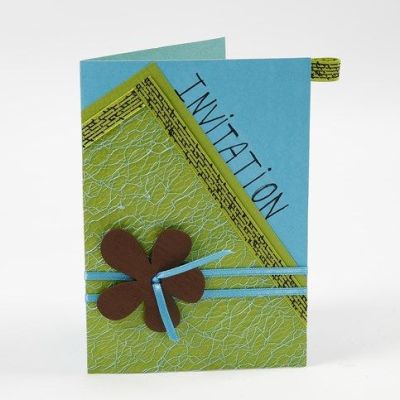 Une carte de vœux avec du tissu en filet et une fleur sur un ruban en satin.