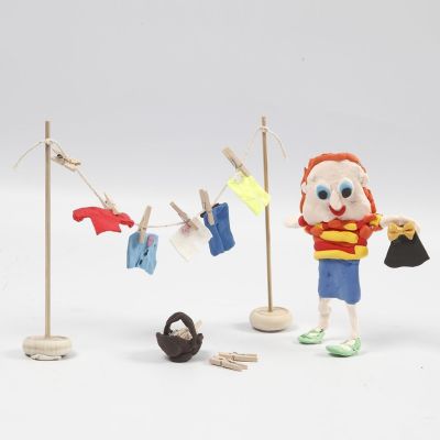 Une figurine en p&acirc;te Silk Clay et un &eacute;tendoir en bois avec des habits en p&acirc;te Silk Clay