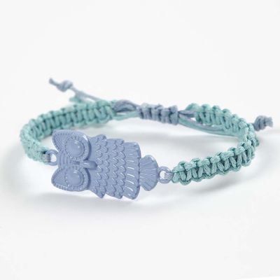 Un bracelet tressé décoré d'un pendentif en métal vernis