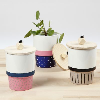 Une tasse décorée avec de la peinture pour porcelaine et un couvercle avec une perle en bois