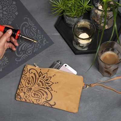 Une pochette en papier simili cuir décorée d’un motif ethnique à l’aide d’un pyrograveur