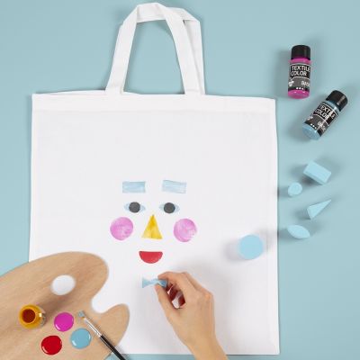 Un sac de courses d&eacute;cor&eacute; d&rsquo;un motif de visage imprim&eacute; au tampon