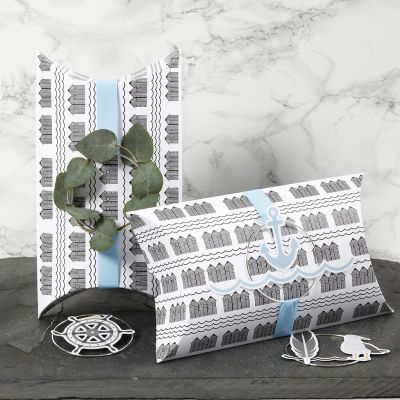 Des boîtes cadeaux à plier décorées avec du ruban bleu