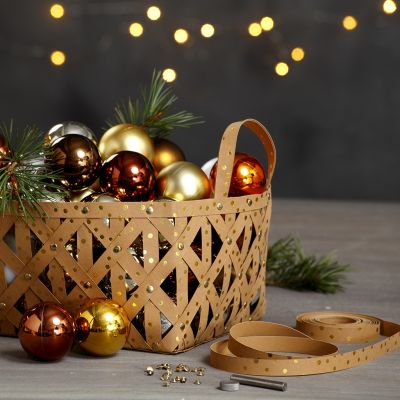Un panier réalisé avec des bandes d’étoiles en papier imitation cuir et des rivets.