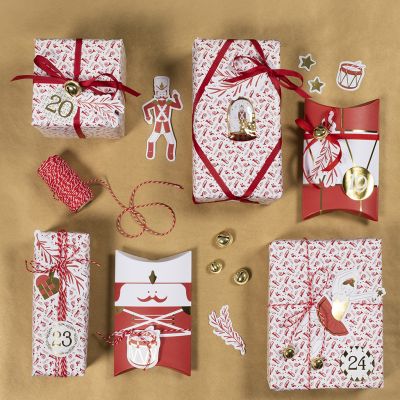Emballage cadeau de Noël avec des stickers Casse-Noisette et des découpes en papier design.
