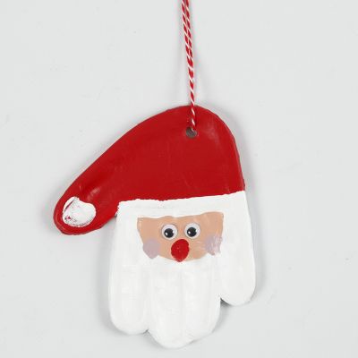 Une empreinte de main en pâte autodurcissante décorée en Père Noël