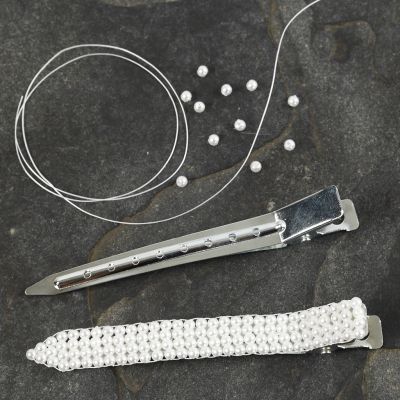 Une pince à cheveux avec des perles de cire cousues
