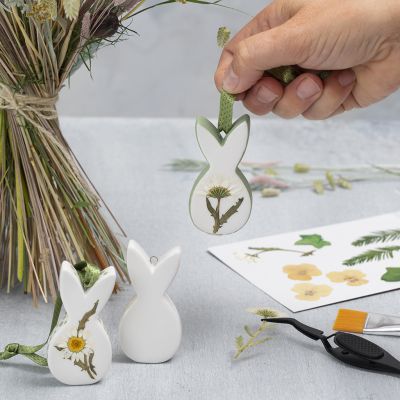 Décorations de Pâques suspendues en porcelaine avec fleurs séchées.