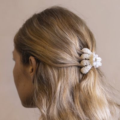 Une pince à cheveux décorée de demi-perles et de mini perles de verre nacrées.
