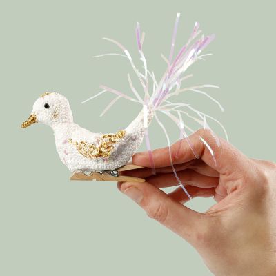 Un oiseau en Foam Clay sur une pince à linge en bois.