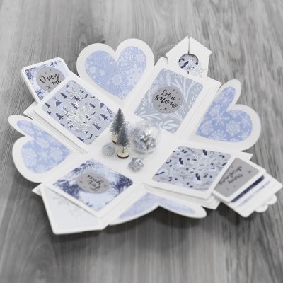 Une boîte explosion décorée avec du papier à motifs et un Winter Wonderland.