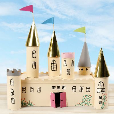 Un ch&acirc;teau de conte de f&eacute;es r&eacute;alis&eacute; &agrave; partir d&rsquo;une bo&icirc;te en carton et de tubes en carton, d&eacute;cor&eacute; avec de la peinture pour loisirs cr&eacute;atifs.