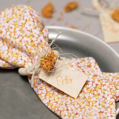 Serviettes réalisées en tissu patchwork et anneau de serviette décoré de fleurs séchées.