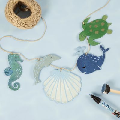 Une guirlande avec des créatures marines en bois décorées avec de la peinture artisanale.