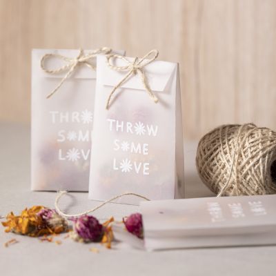 Un sac en papier calque avec des fleurs séchées pour le confetti.